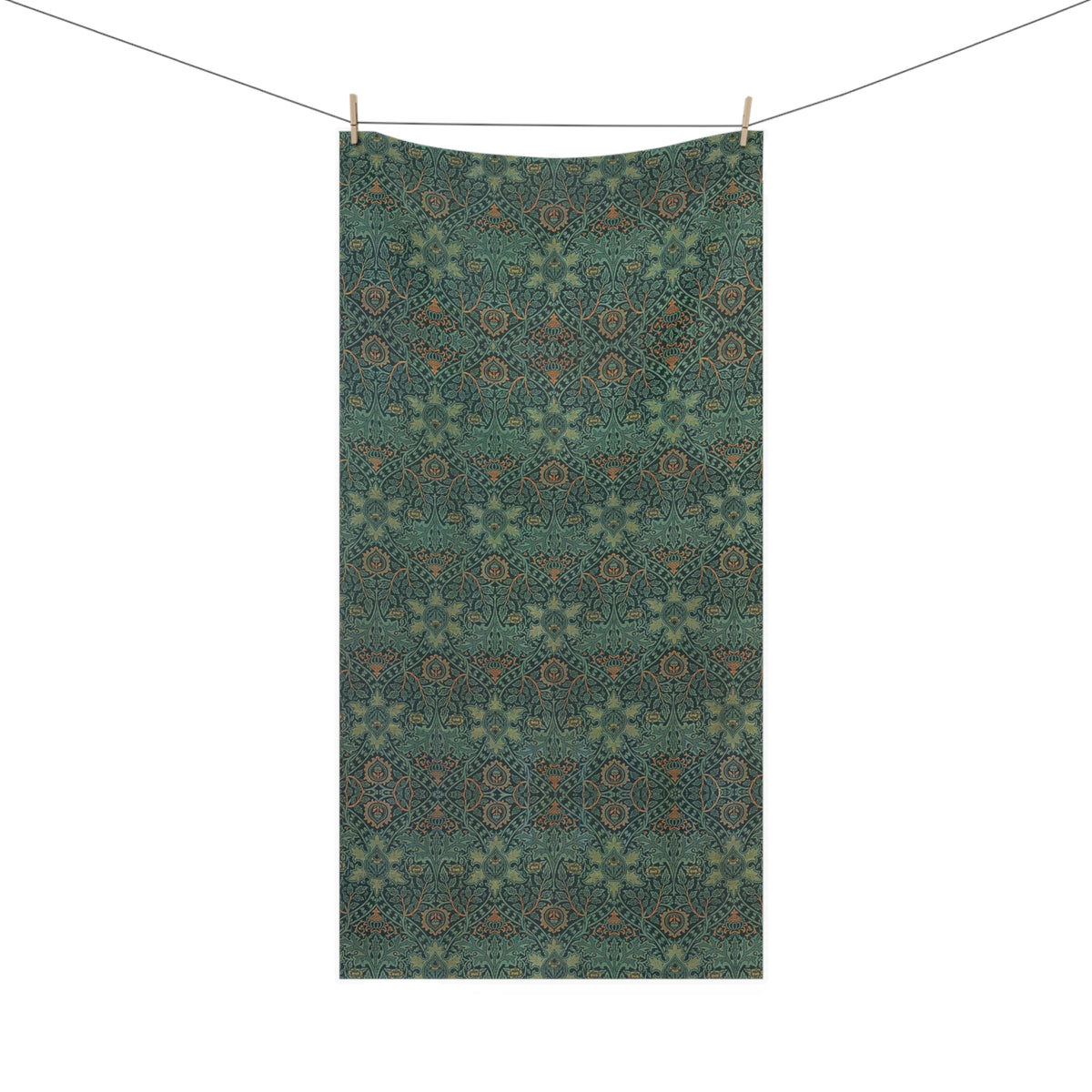 A rectangular bath towel hanging from a clothesline with two wooden clips, featuring an intricate repeating geometric and floral pattern in teal, olive green, and brown tones, set against a plain white background.