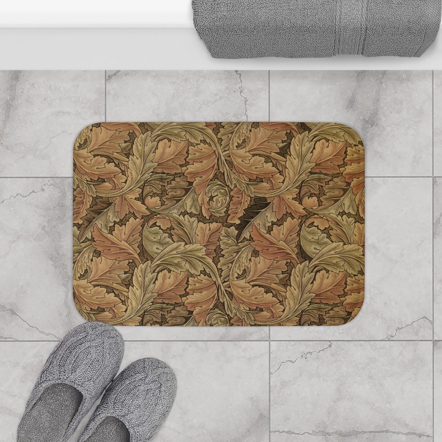 Decorative doormat with leaf pattern on a marble floor with slippers and a towel.