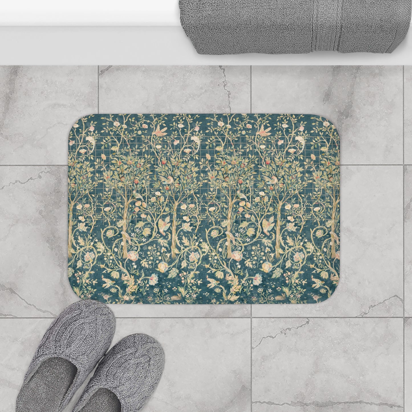 Decorative doormat with floral pattern on a tiled floor, next to slippers and a bath mat.