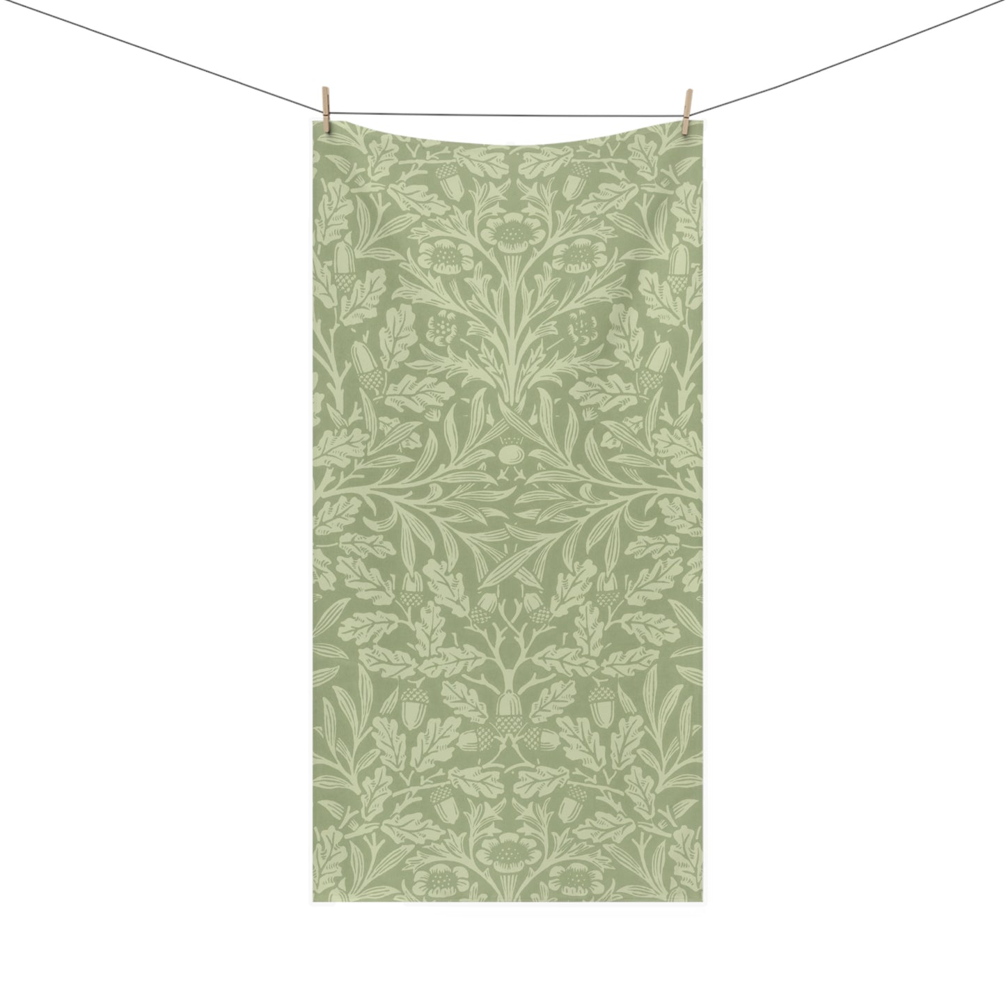 A rectangular fabric towel with an all-over botanical damask pattern in sage green and light sage green, hanging from a clothesline with two wooden clips against a plain white background.