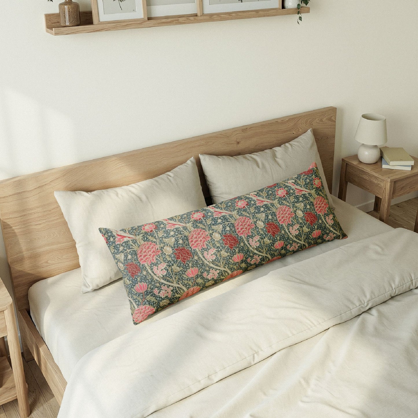 Floral patterned pillow on a bed with wooden headboard and nightstand.