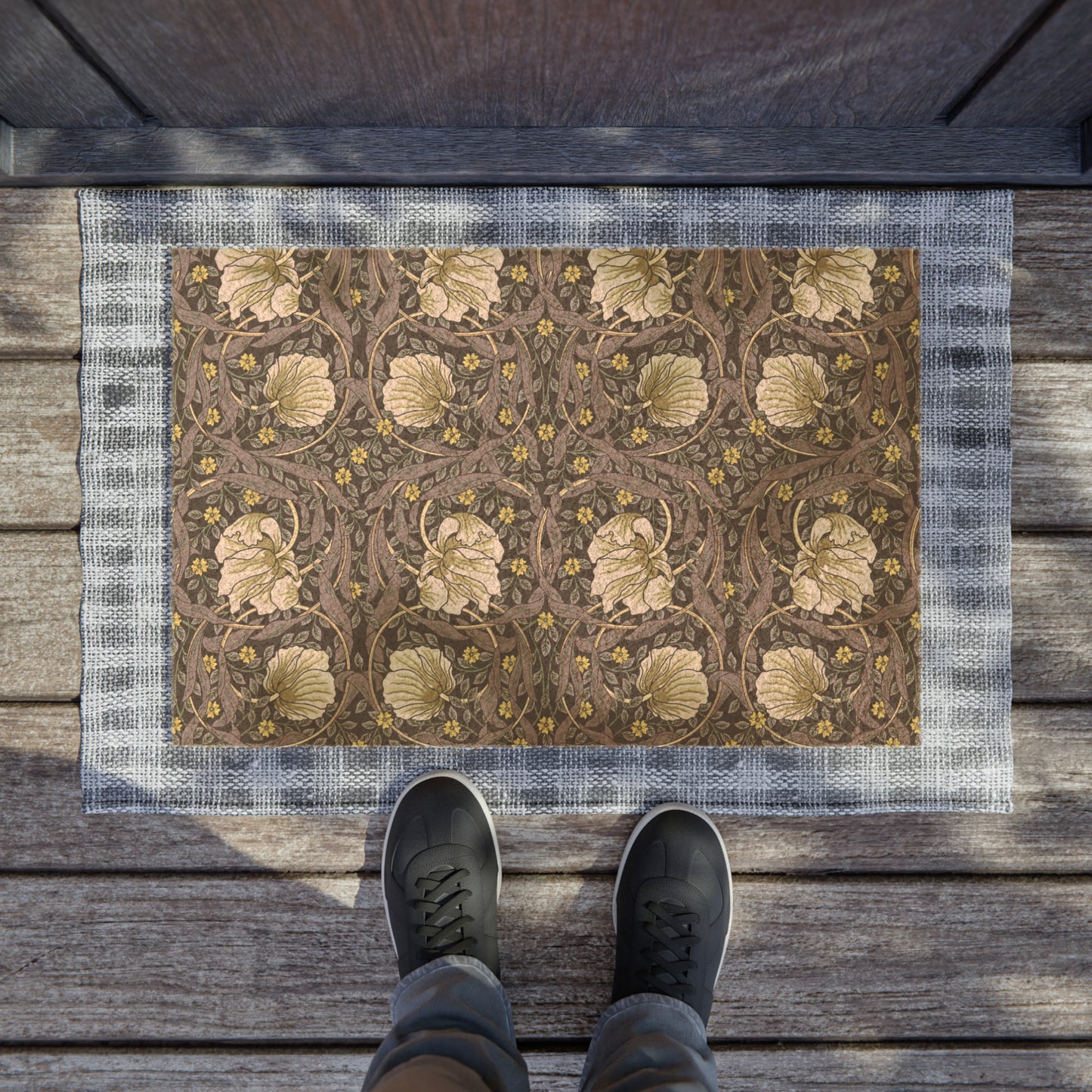 A rectangular coconut coir doormat with an intricate floral William Morris & Co pattern in shades of lavender and gold, with a black vinyl backing.
