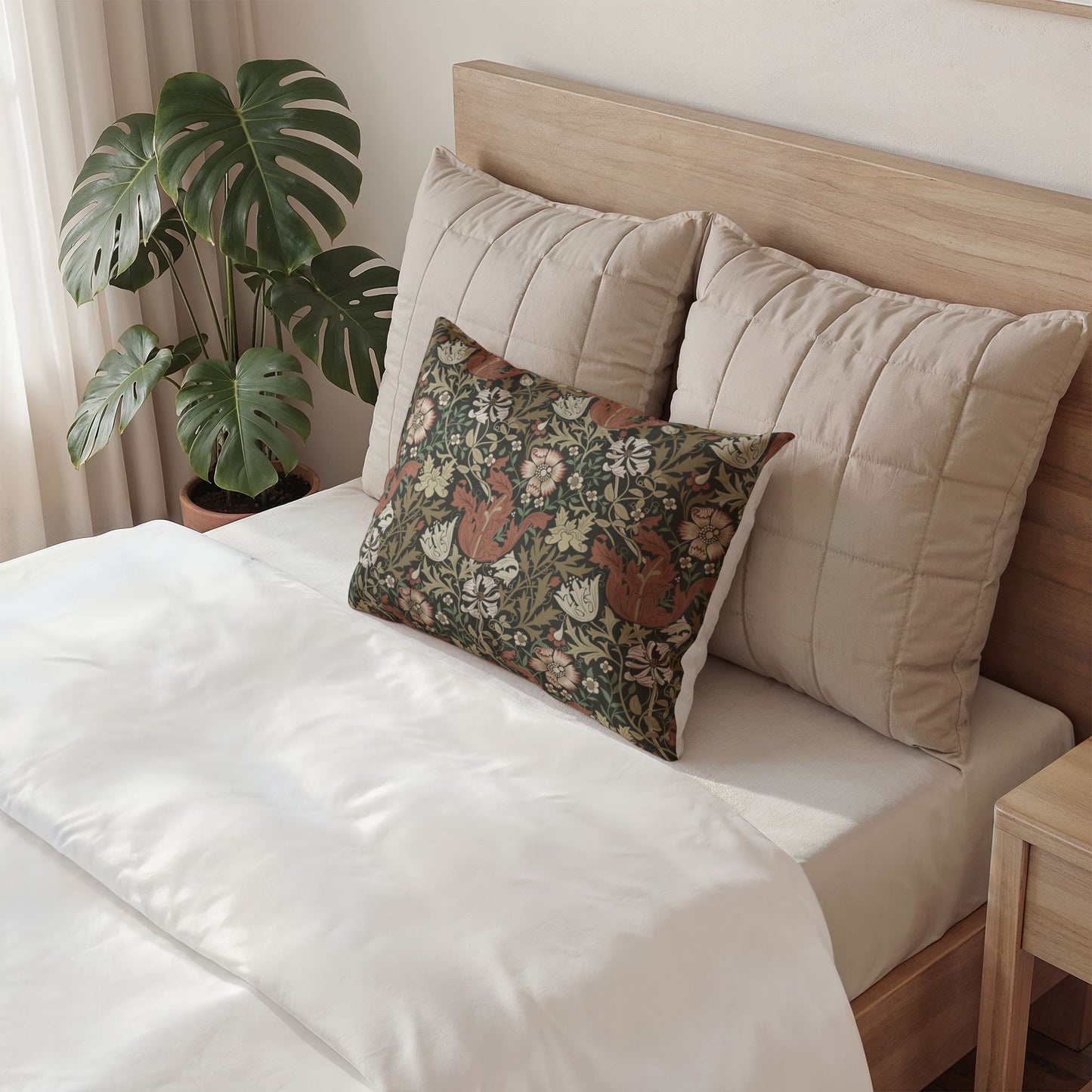 Bed with beige pillows and a green pillow, next to a plant in a room.