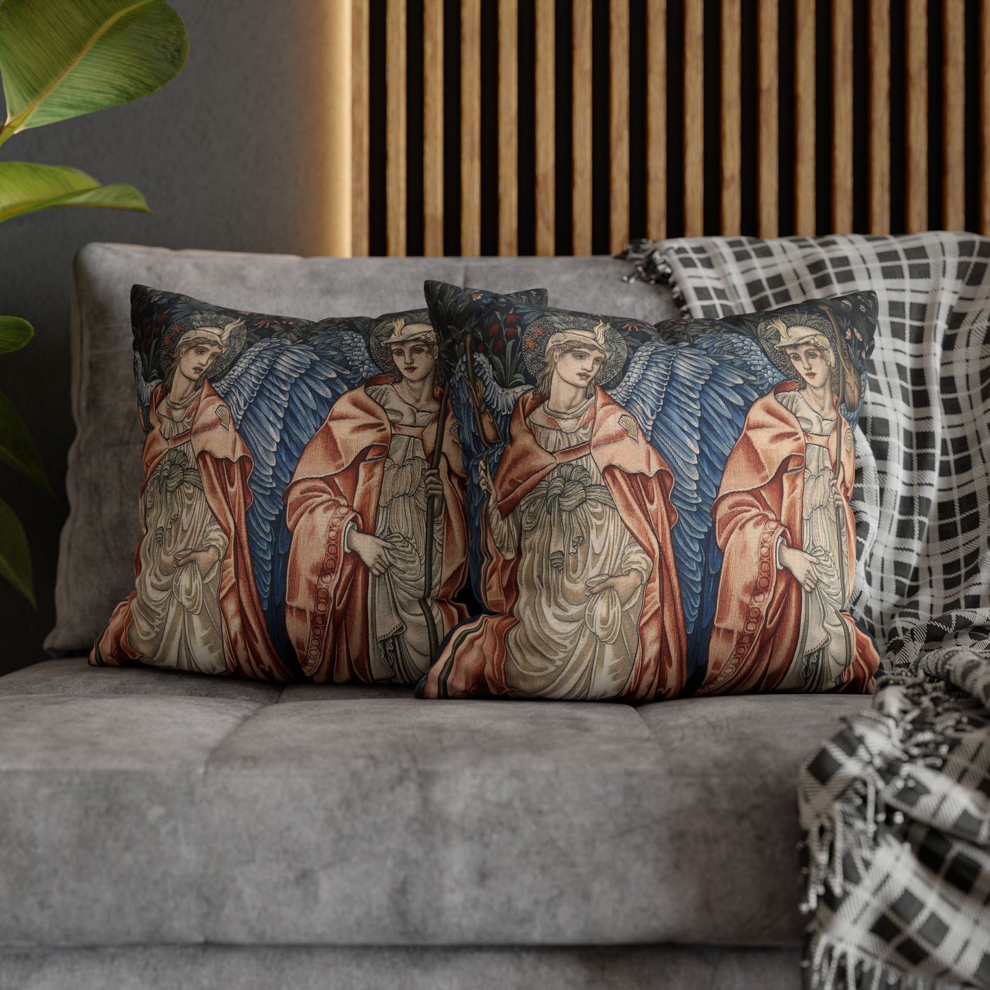 Decorative pillows with angel designs on a gray sofa.
