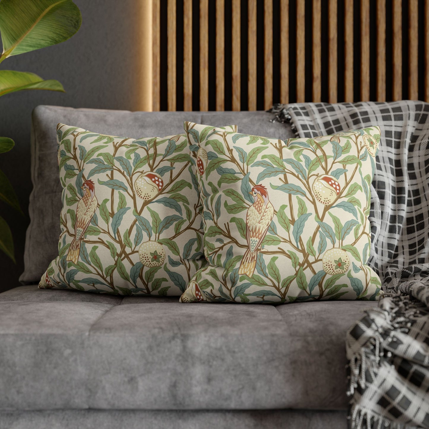 Decorative pillows with bird and floral pattern on a gray sofa.