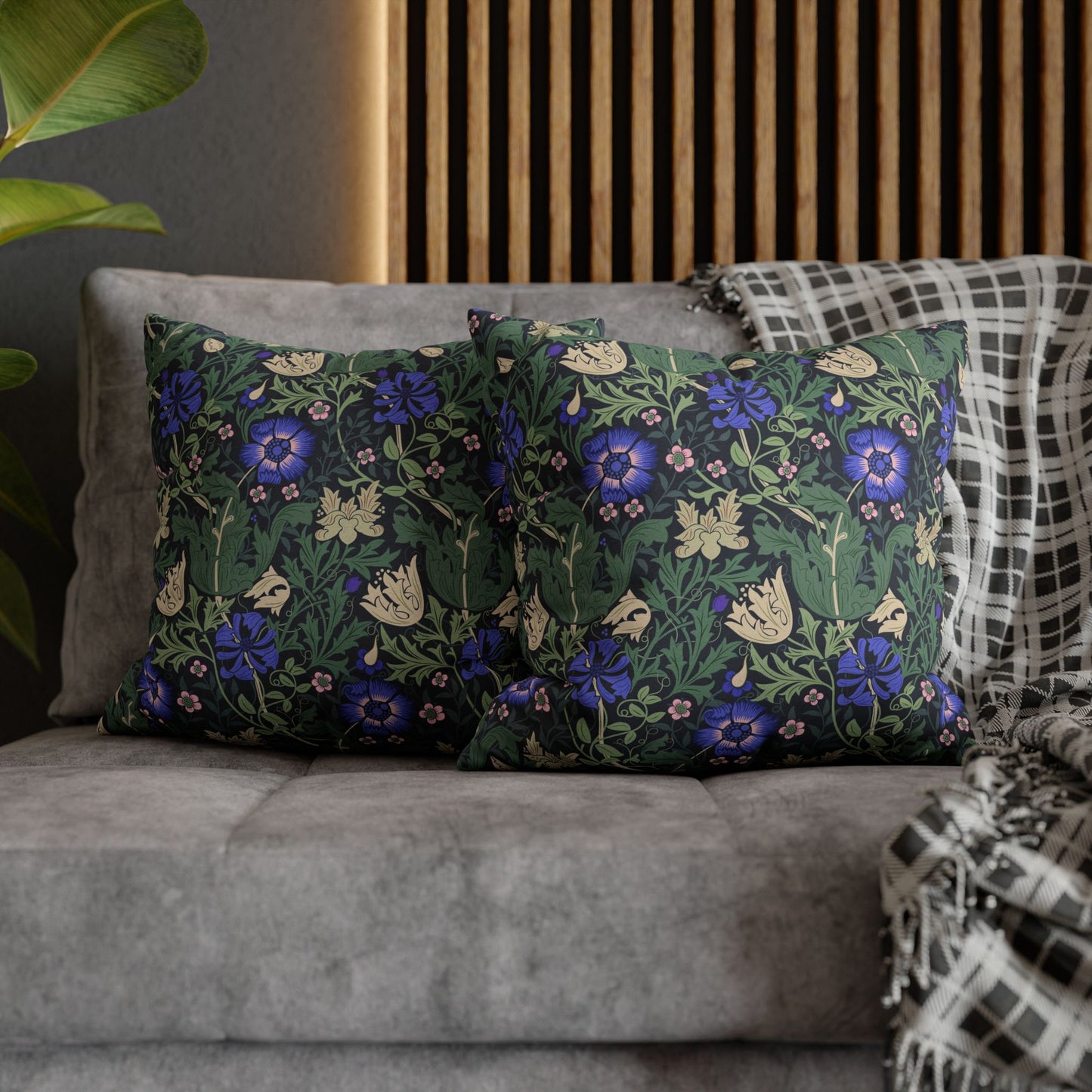 Floral patterned cushions on a gray sofa with a wooden headboard in the background.