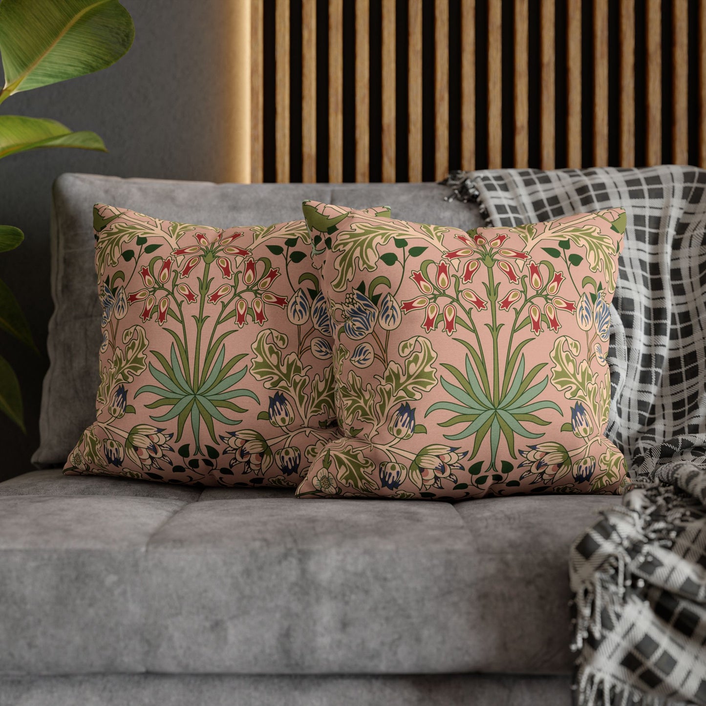 Floral patterned cushions on a gray sofa with a wooden headboard in the background