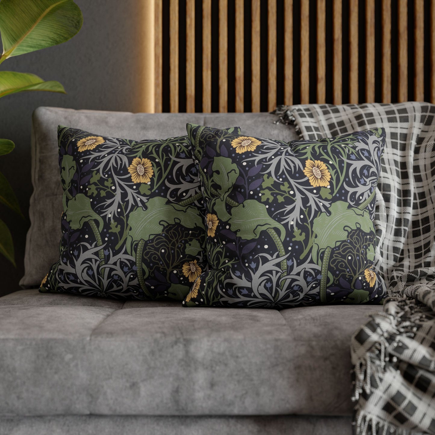 Decorative pillows with floral patterns on a gray sofa against a wooden headboard.