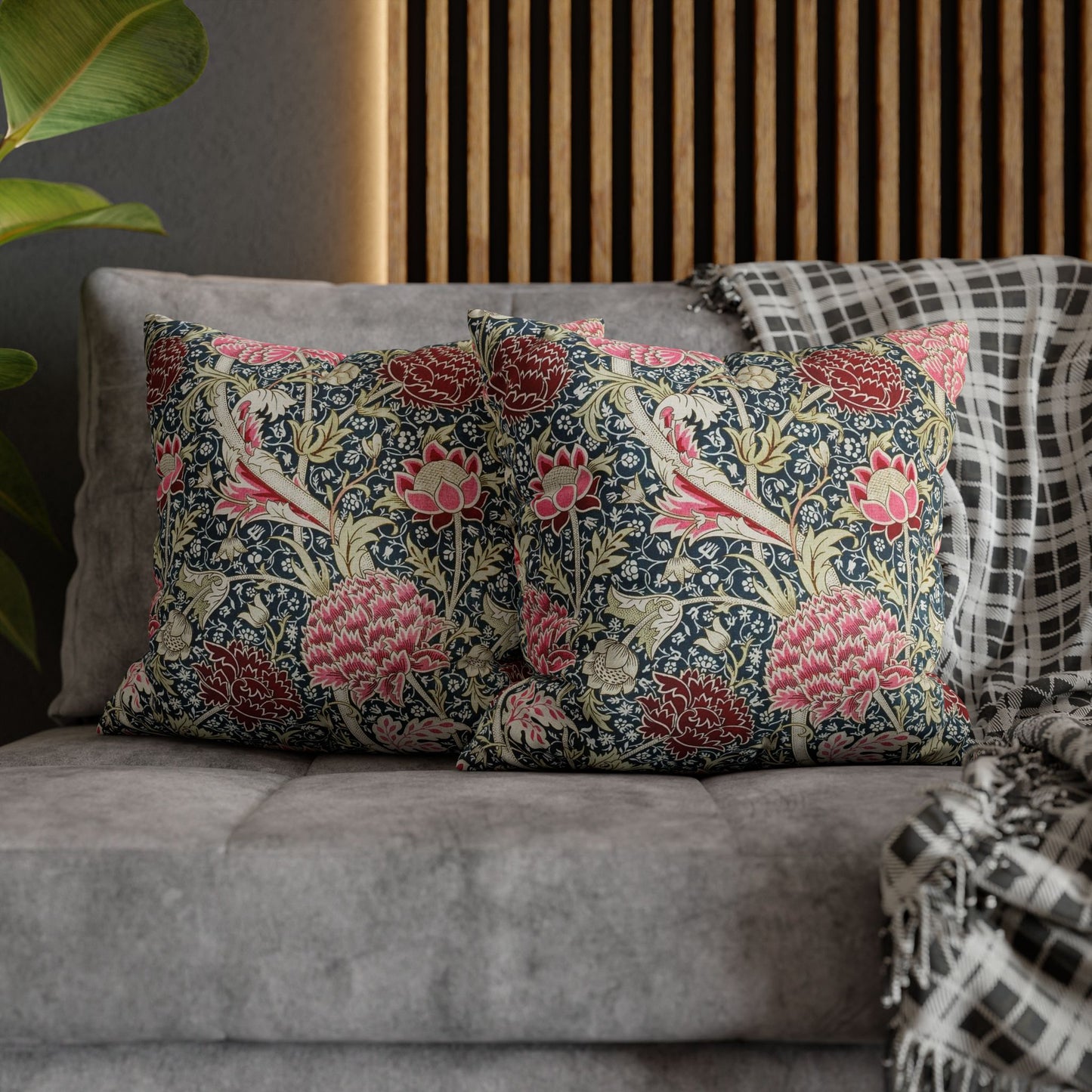 Floral patterned cushions on a gray sofa with a wooden headboard in the background.