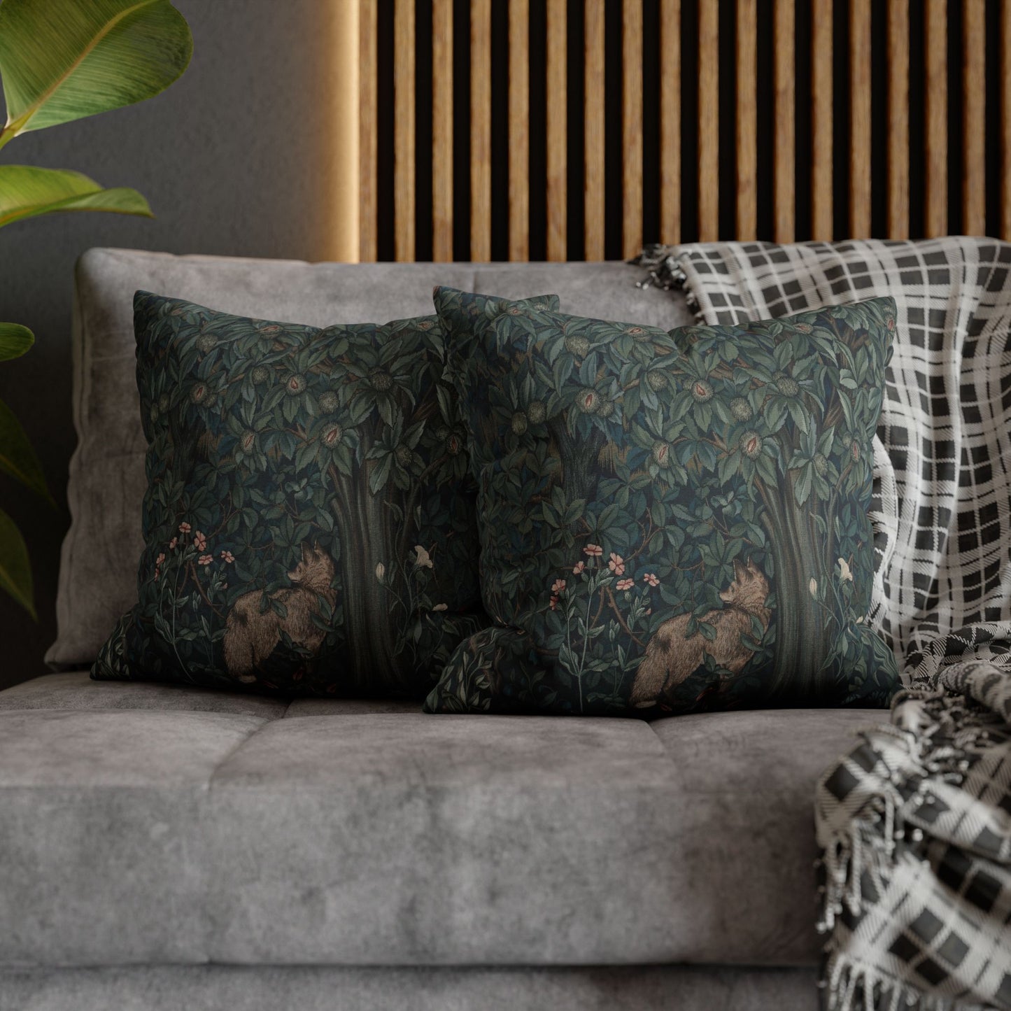 Decorative pillows with nature-themed patterns on a gray sofa against a wooden panel wall - William Morris Greenery