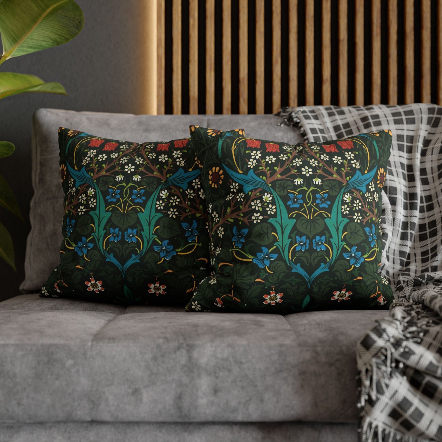 Decorative pillows with floral patterns on a gray sofa against a wooden headboard _ William Morris Tulip