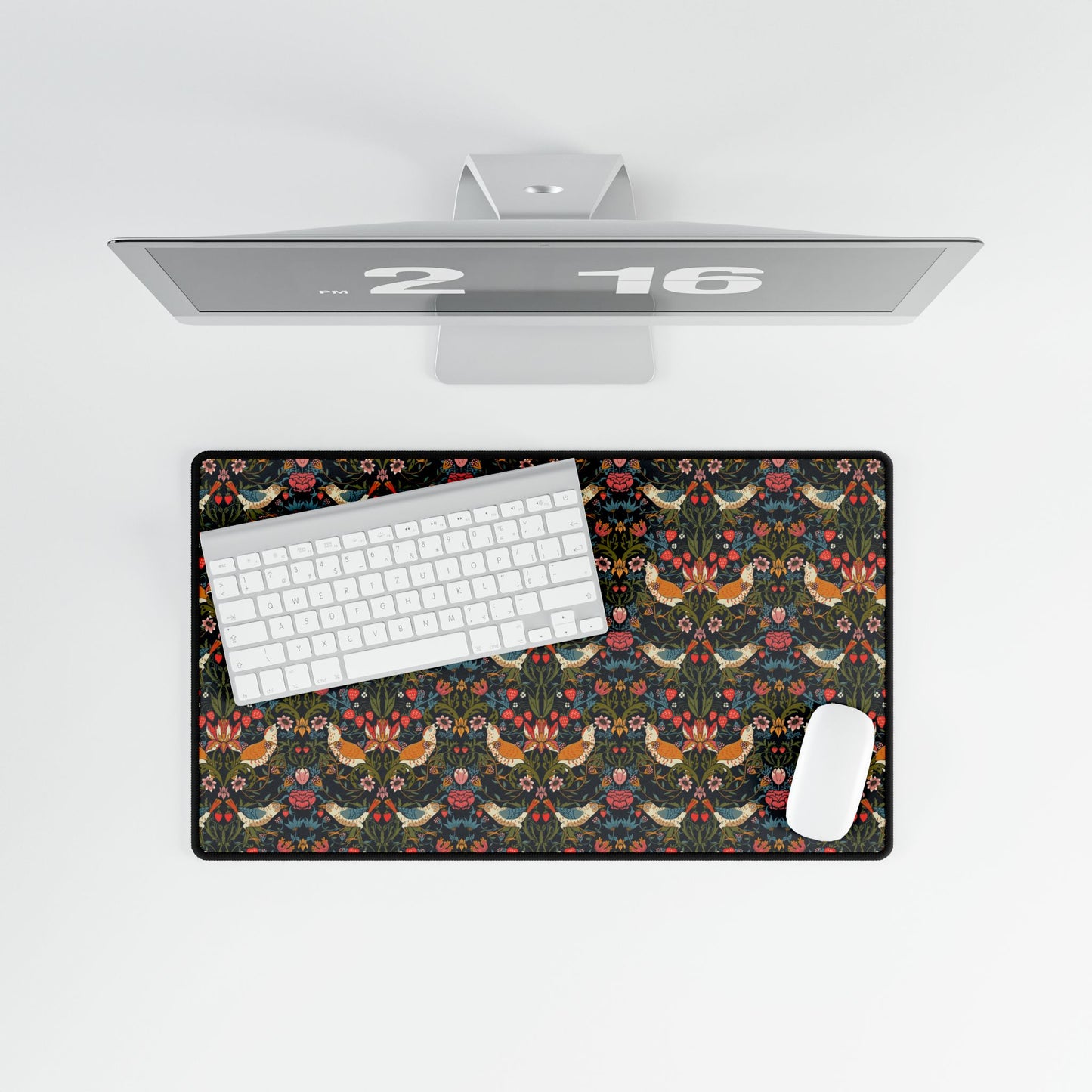 Desk setup with a floral mouse pad, keyboard, and mouse on a white surface.