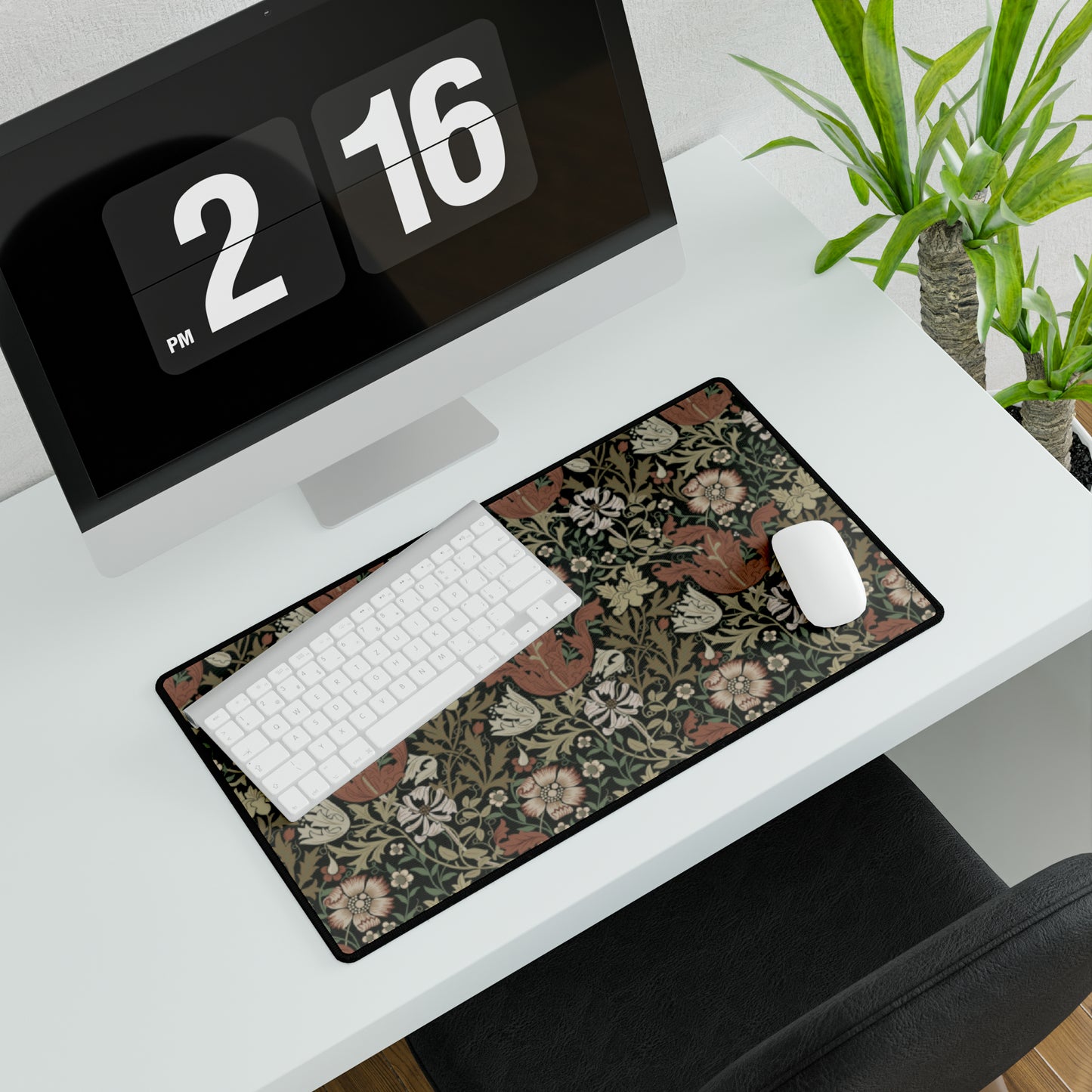 A large, rectangular neoprene desk mat with a William Morris & Co floral pattern, displayed under a computer monitor and keyboard, illustrating its use in a workspace.