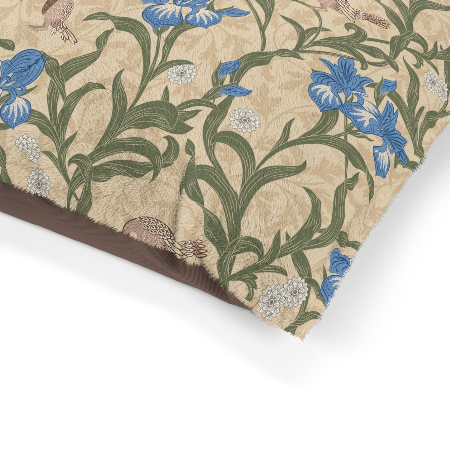 Floral patterned dog bed with blue flowers and green leaves on a beige background