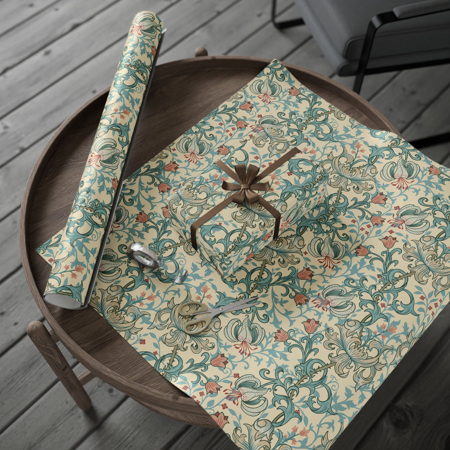Floral-patterned gift wrap with a brown ribbon on a wooden surface