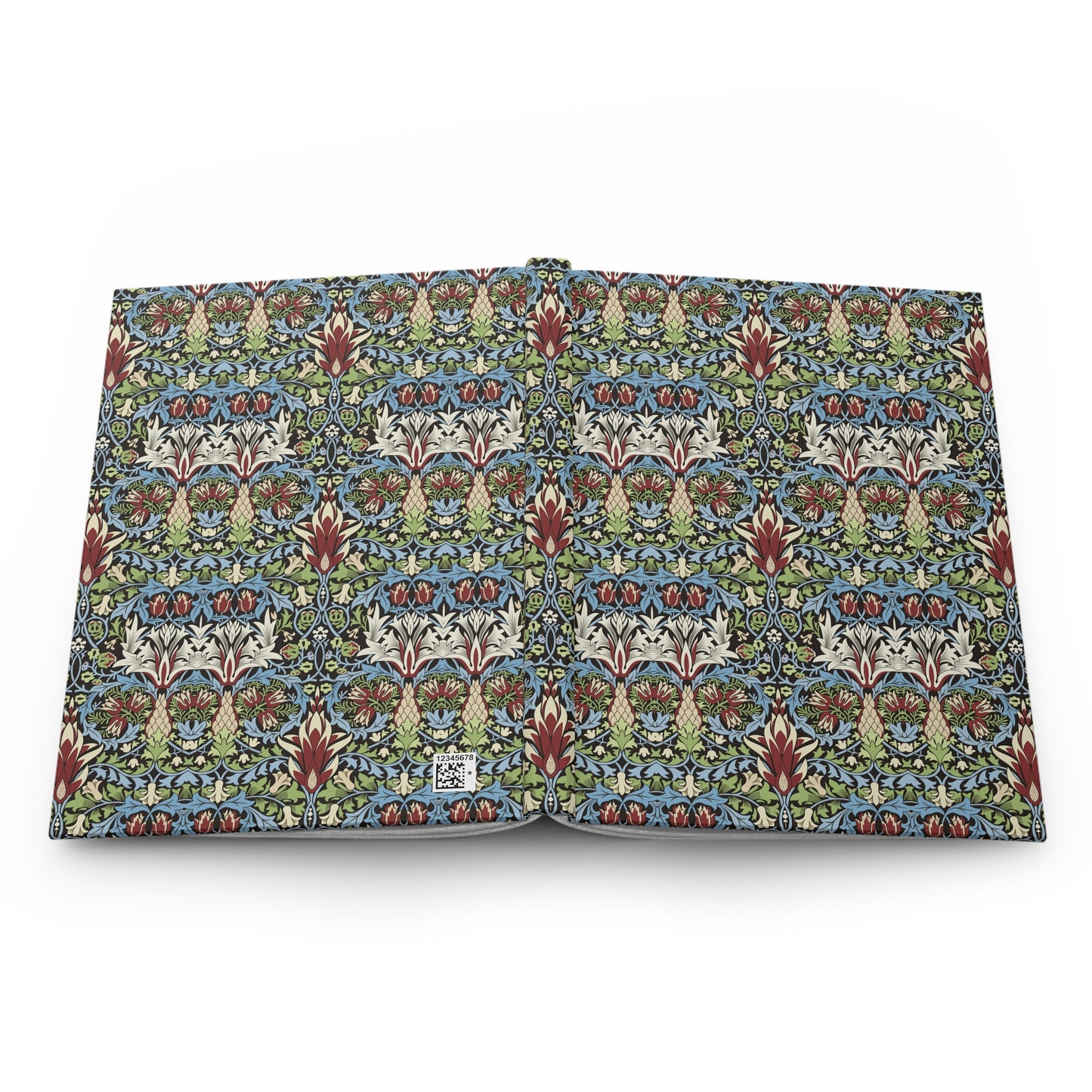 An open book or notebook showing a detailed, repeating Arts and Crafts style floral pattern in blue, green, red, and cream on the pages, photographed against a plain white background.