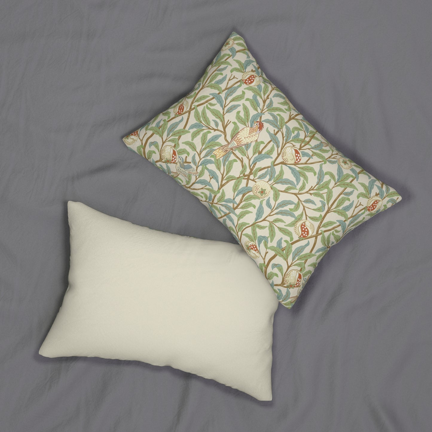 A rectangular William Morris & Co lumbar cushion with a bird and pomegranate design on a light background, featuring a concealed zipper.