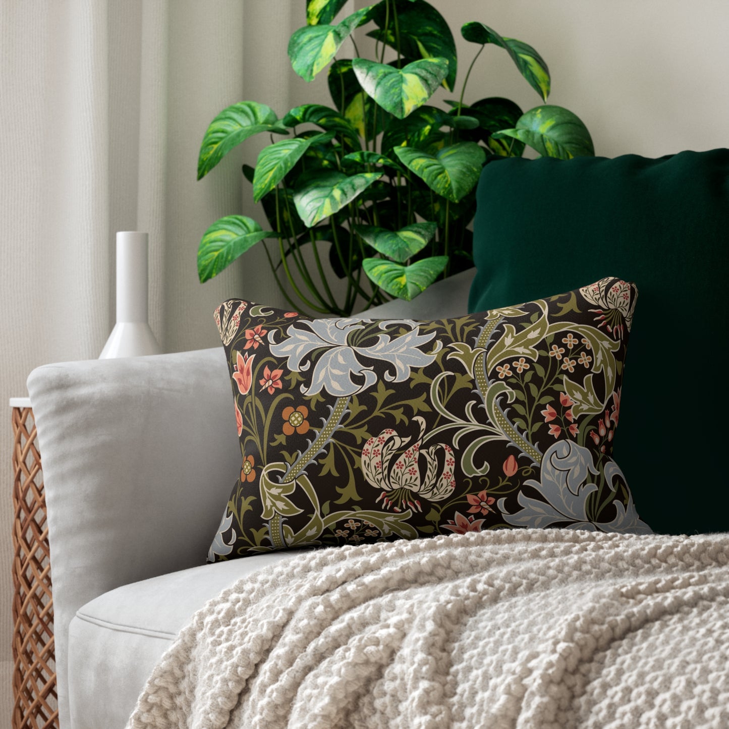 A rectangular lumbar cushion with a William Morris & Co floral pattern featuring various colours such as beige, green, brown, and white.