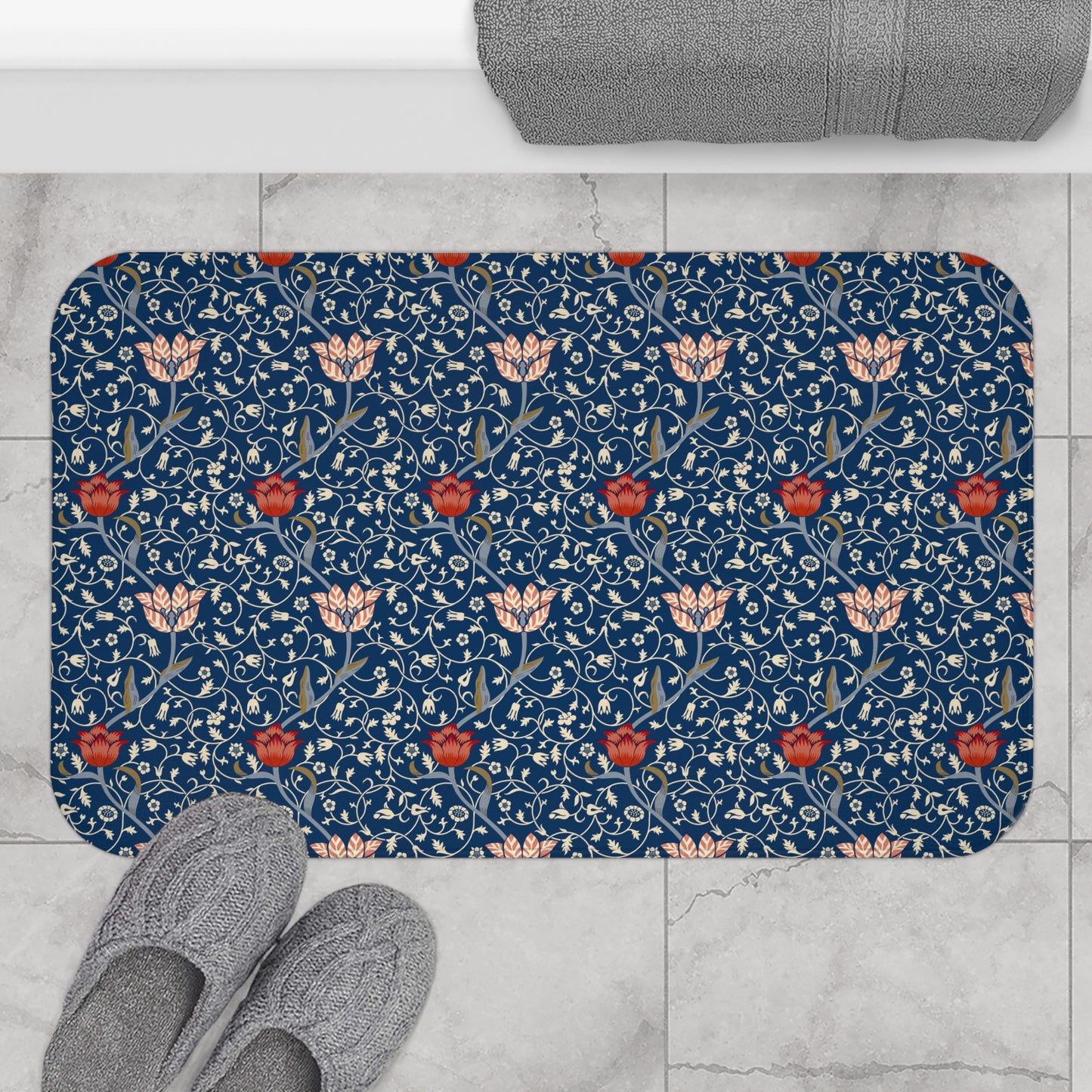 A rectangular microfibre bath mat with a floral pattern inspired by William Morris, predominantly blue with red and white accents.
