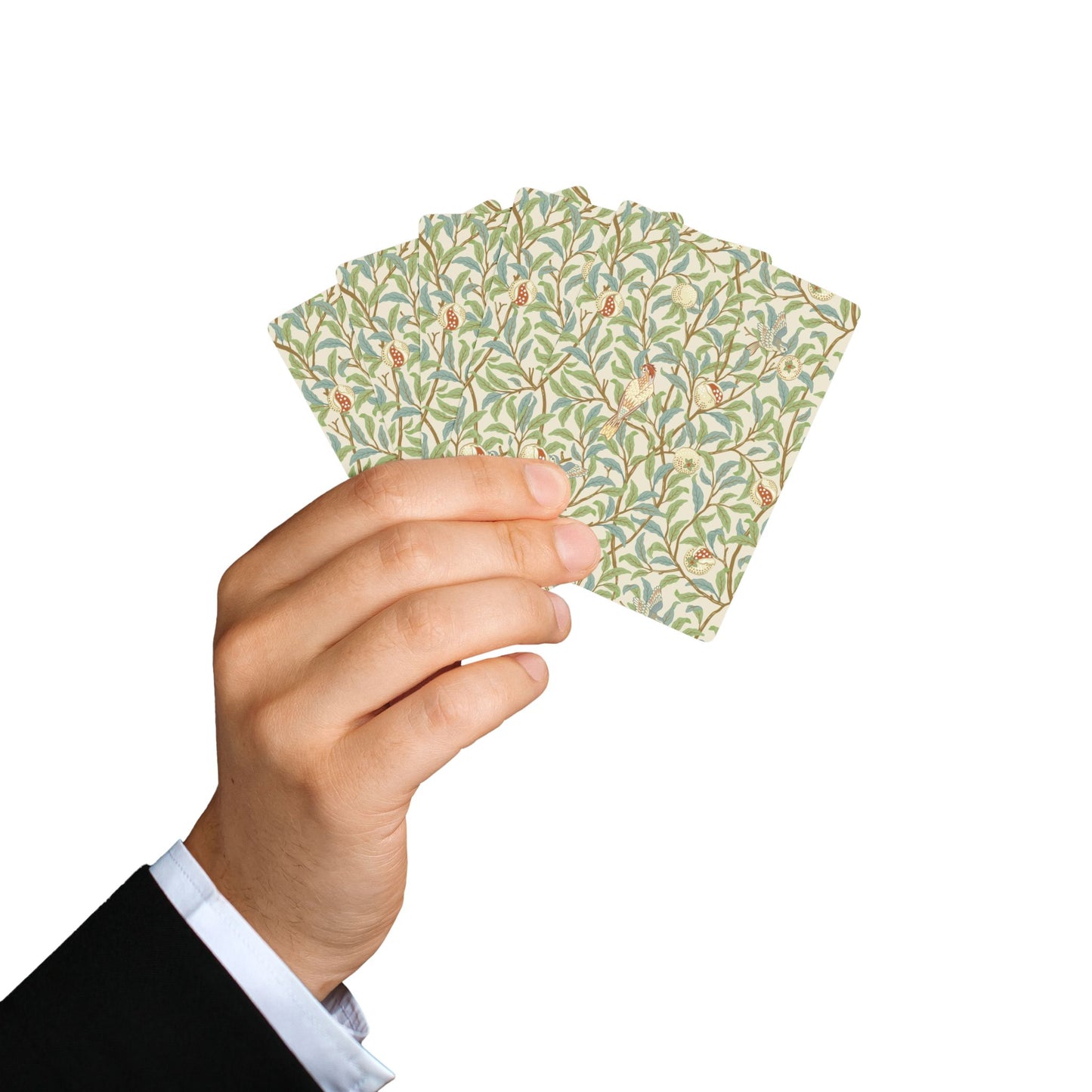 Hand holding a deck of playing cards with a floral pattern on a white background