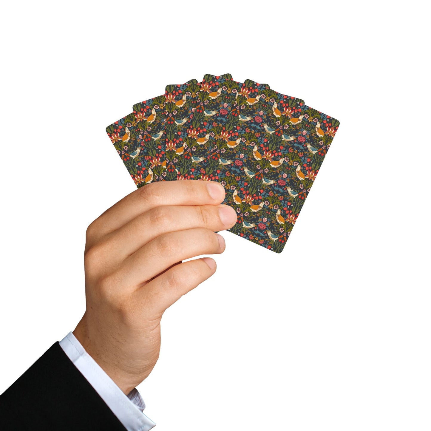 Hand holding a deck of playing cards with a floral pattern on a white background