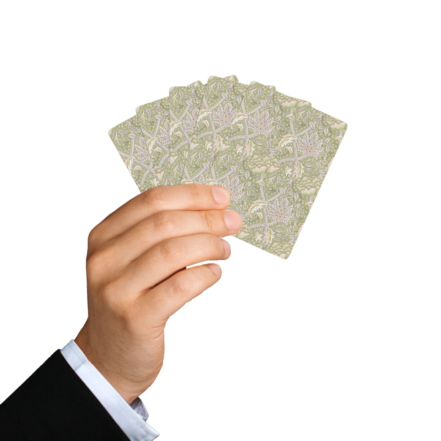Hand holding a deck of playing cards with a floral pattern on a white background