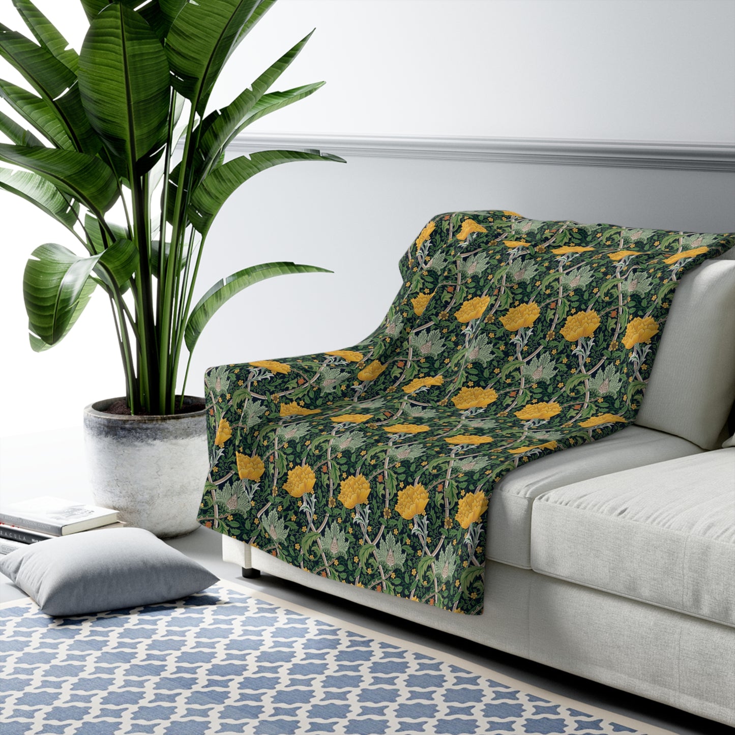 A plush fleece blanket with a yellow chrysanthemum pattern on a green background, laid flat.