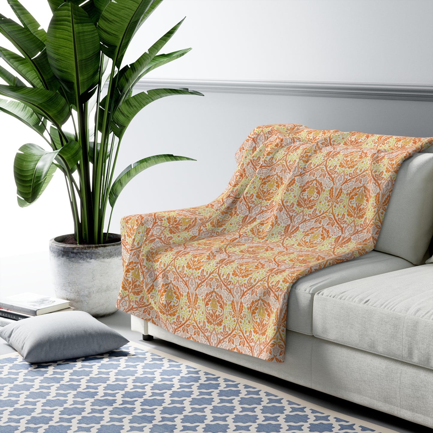A plush fleece blanket with a geometric pattern in orange and cream colours, laid out flat.