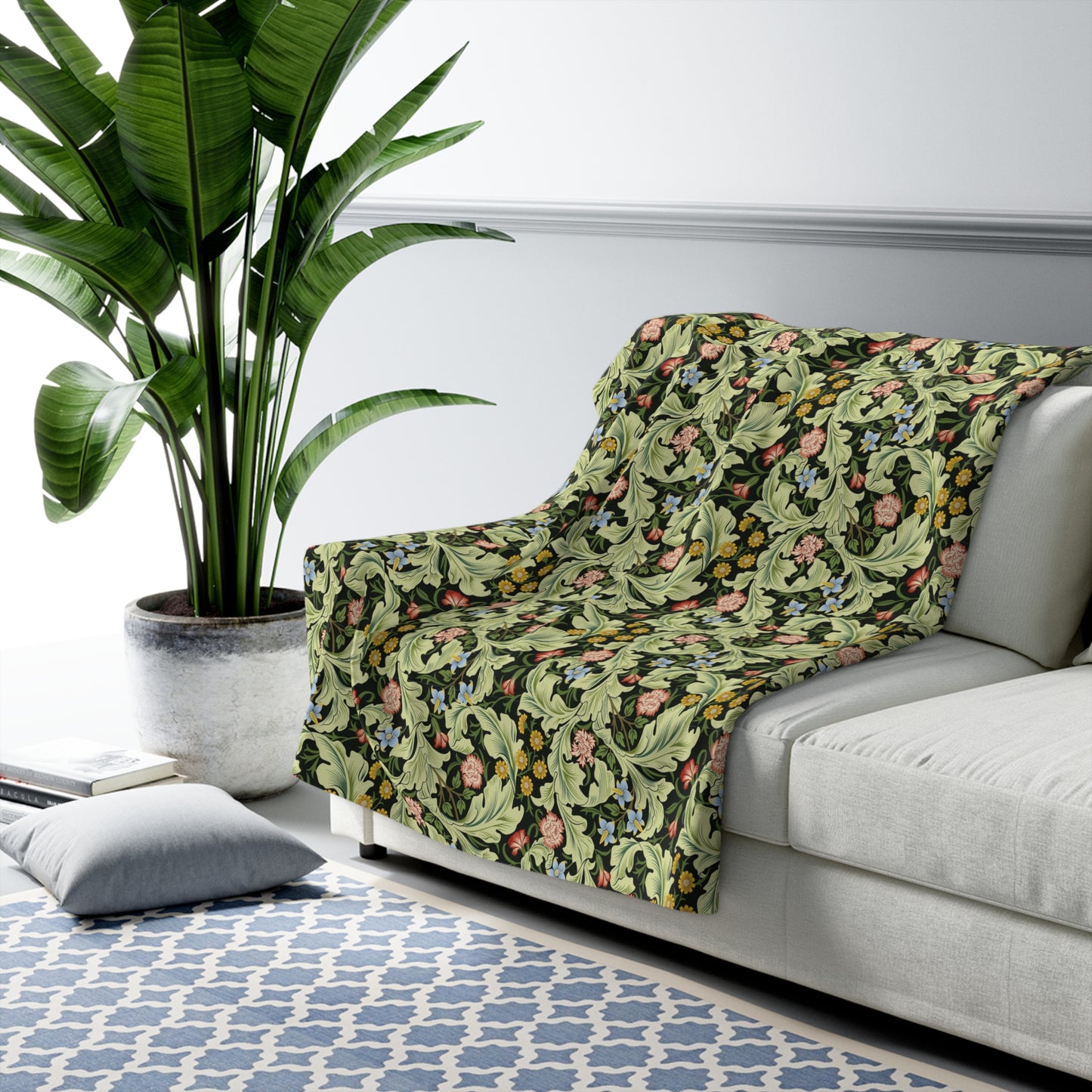 A green Sherpa fleece blanket with a floral pattern inspired by William Morris, displayed flat.
