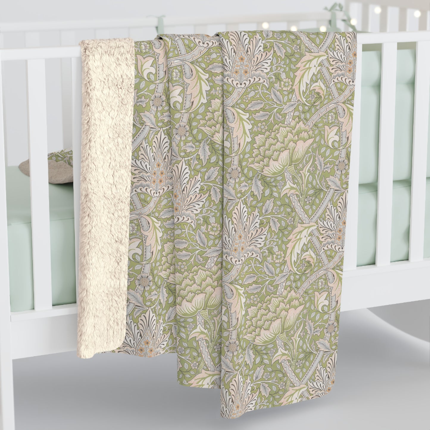 A plush fleece blanket with a floral pattern in green and white tones, inspired by William Morris.
