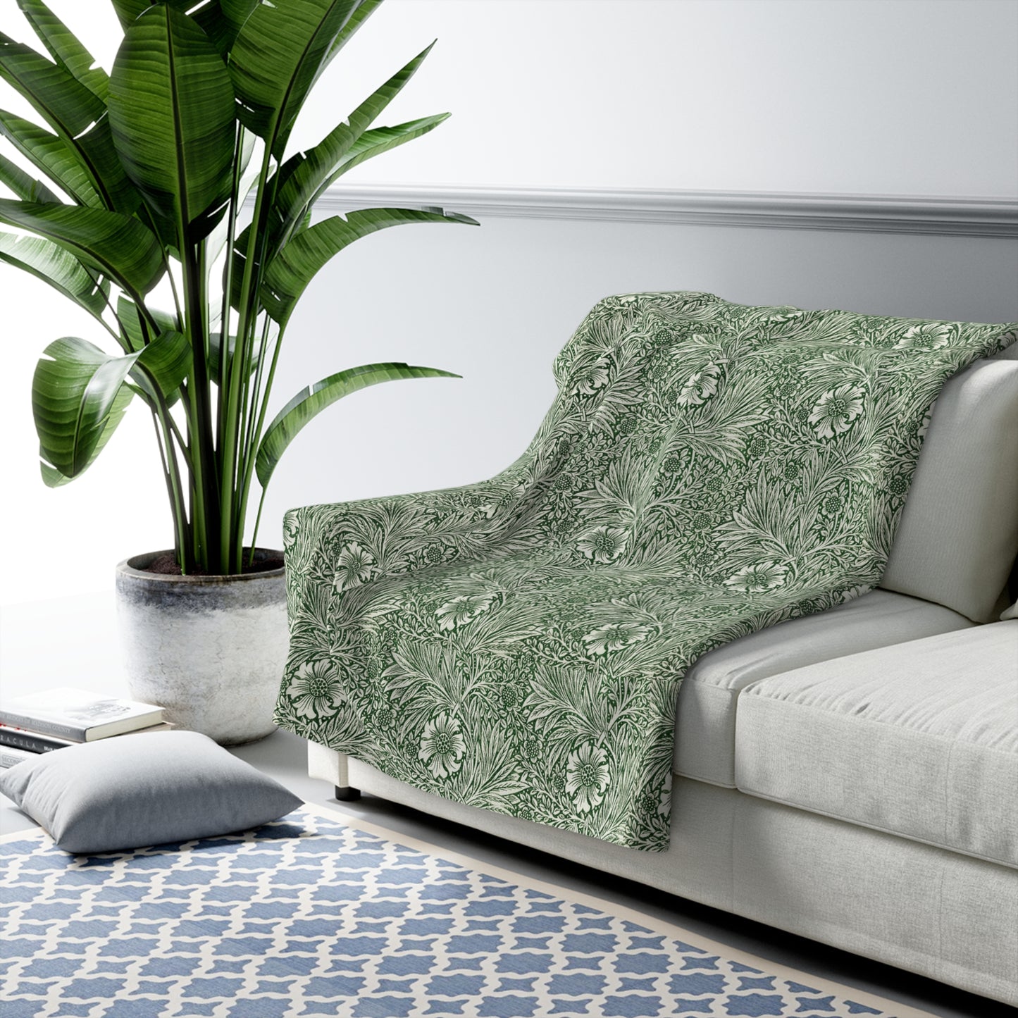 A green Sherpa fleece blanket with a floral pattern inspired by William Morris, displayed flat.