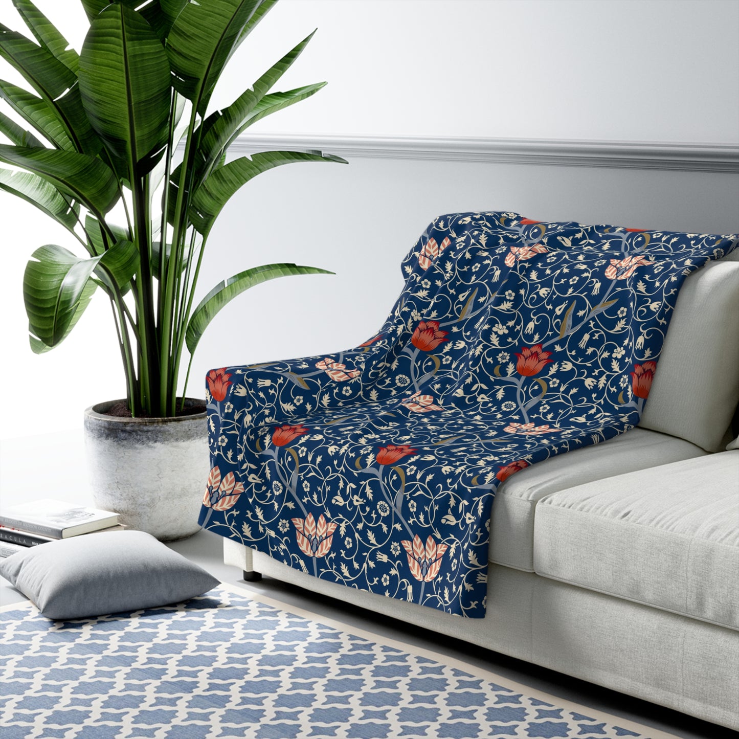 A navy blue Sherpa fleece blanket with a floral pattern inspired by William Morris's design.