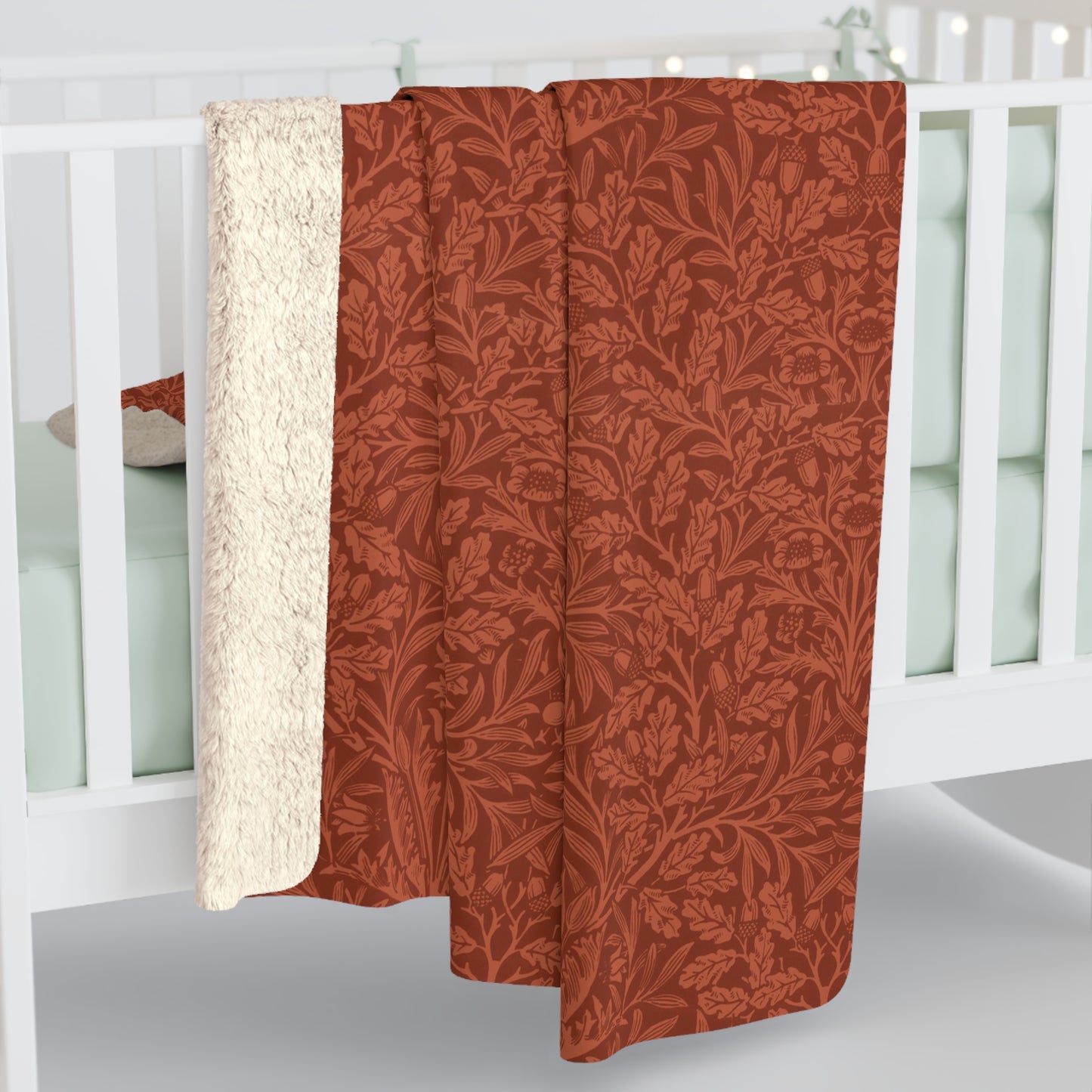 A rectangular Sherpa fleece blanket with a rust-coloured floral pattern inspired by William Morris & Co - Acorns and Oak Trees Collection.