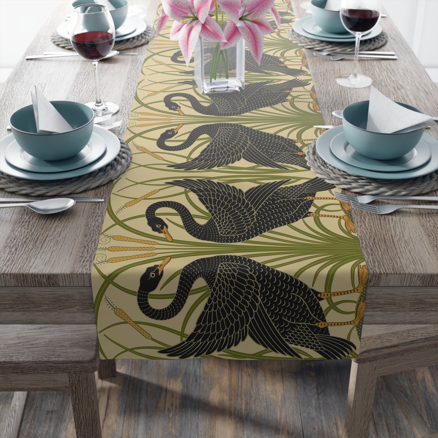 Table setting with a decorative table runner inspired by William Morris & Co featuring black swans on a tan coloured background.
