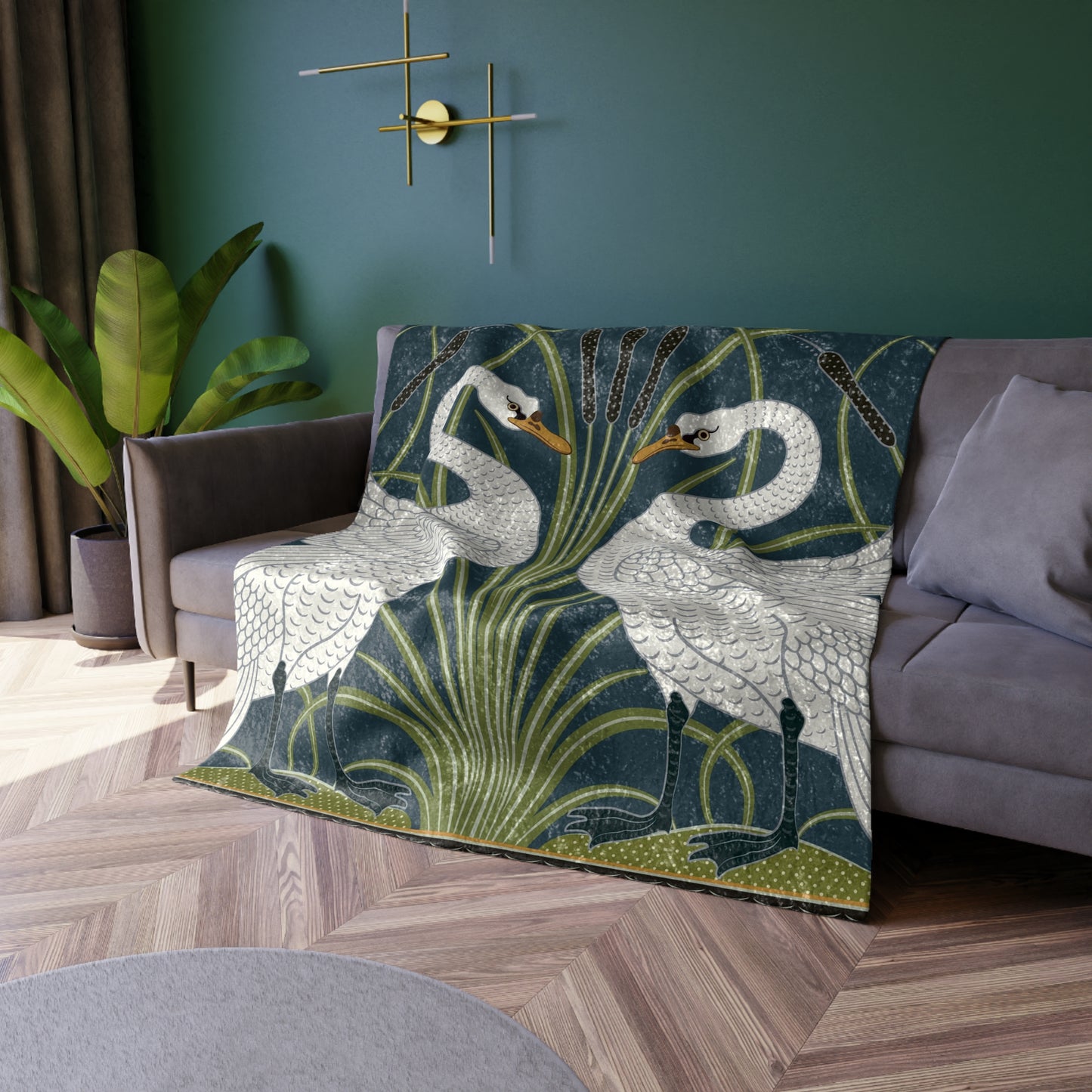 A lush crushed velvet blanket with a pattern inspired by William Morris, featuring a white swan design on a blue background, folded open to show the silky finish.