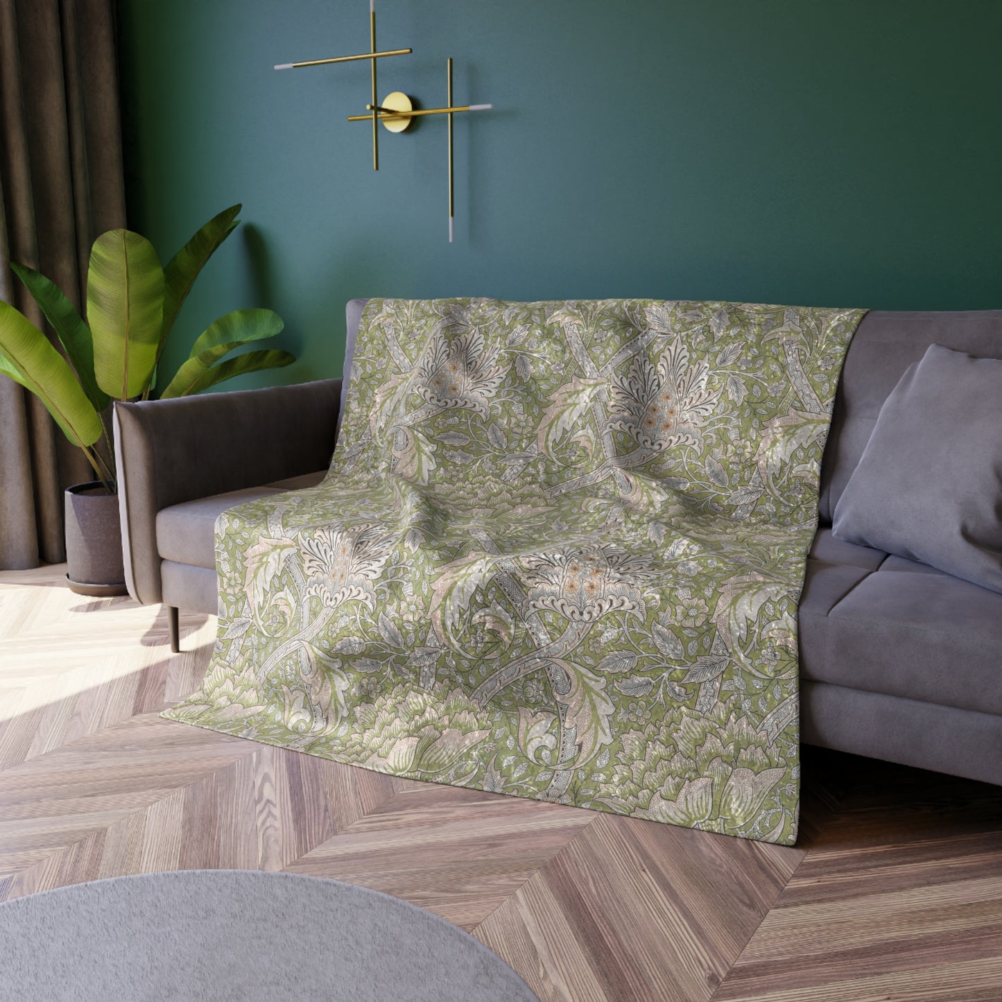A plush, velvet blanket with a floral William Morris & Co pattern in shades of green and beige, laid out with the soft side up.