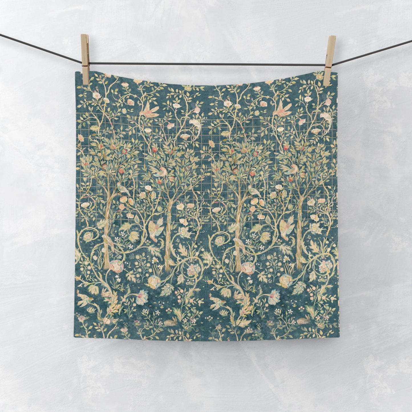 Floral patterned washcloth hanging on a line against a white background