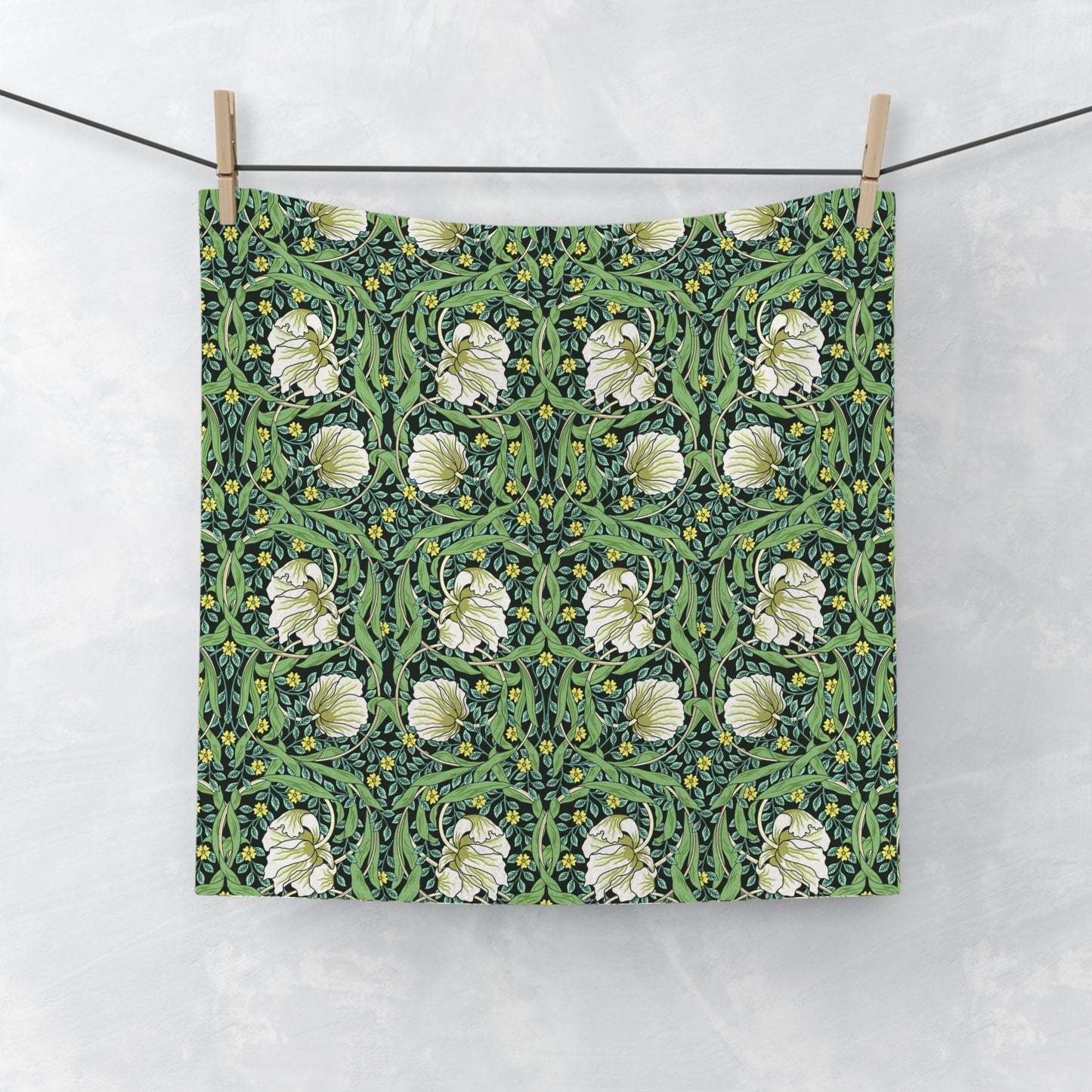 Floral patterned fabric hanging on a line against a white background