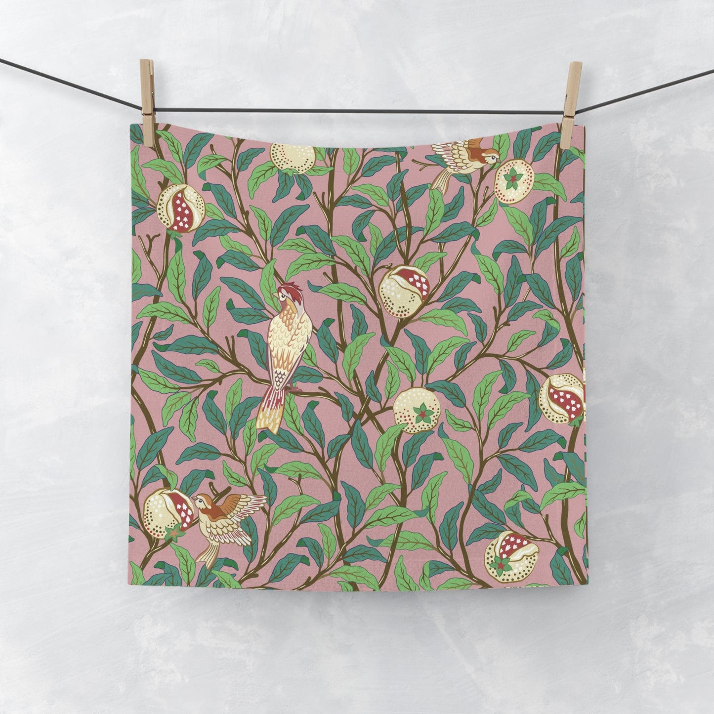 A white washcloth with a floral pattern featuring birds and pomegranates, inspired by William Morris' Bird & Pomegranate Collection.