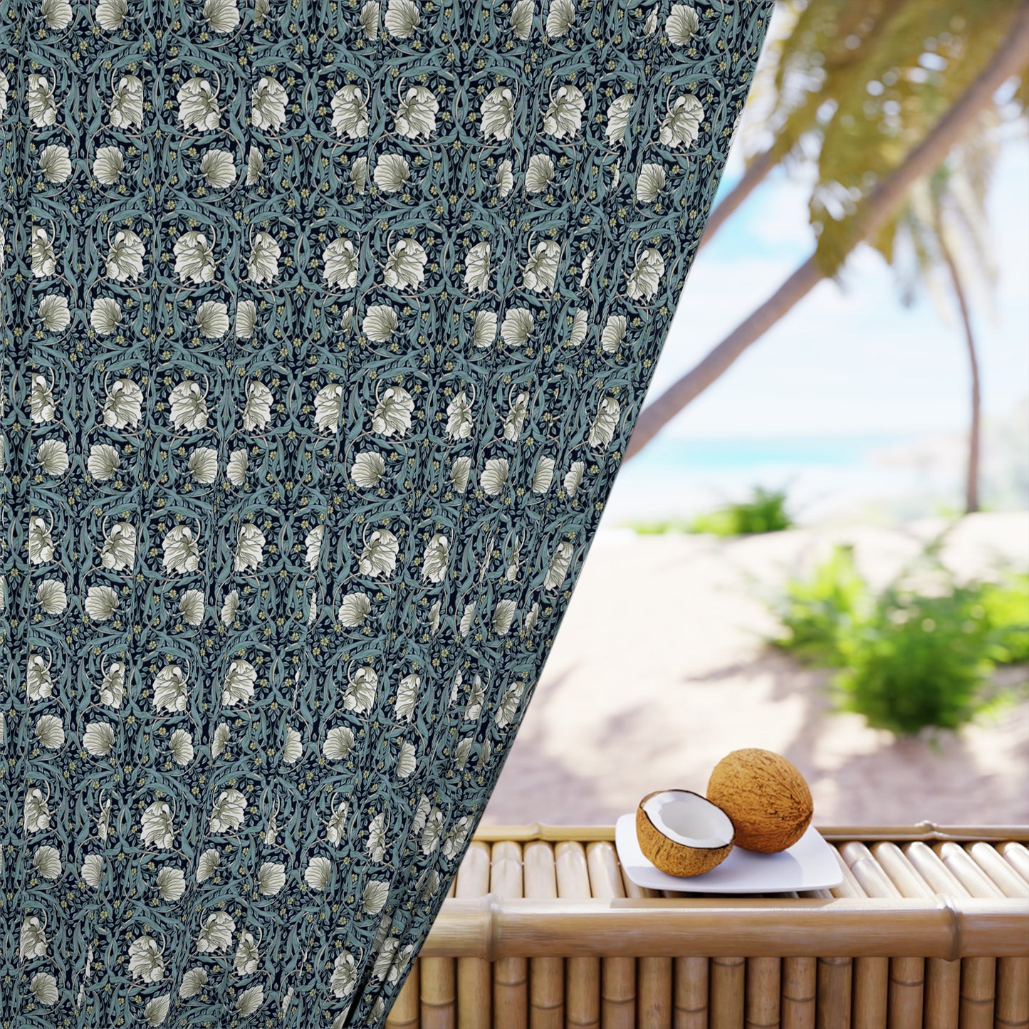 Decorative curtain with floral pattern in front of a beach setting with coconuts on a table.