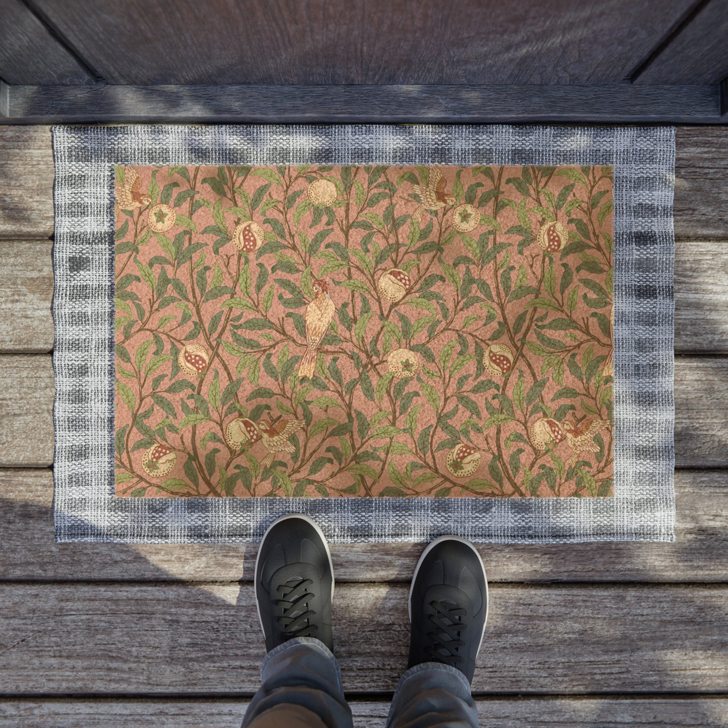 A rectangular coconut coir doormat with an intricate William Morris-inspired bird and pomegranate pattern in rosewood colour.