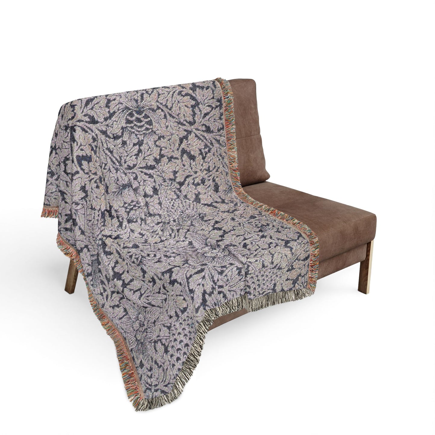Patterned throw blanket draped over a brown chair on a white background