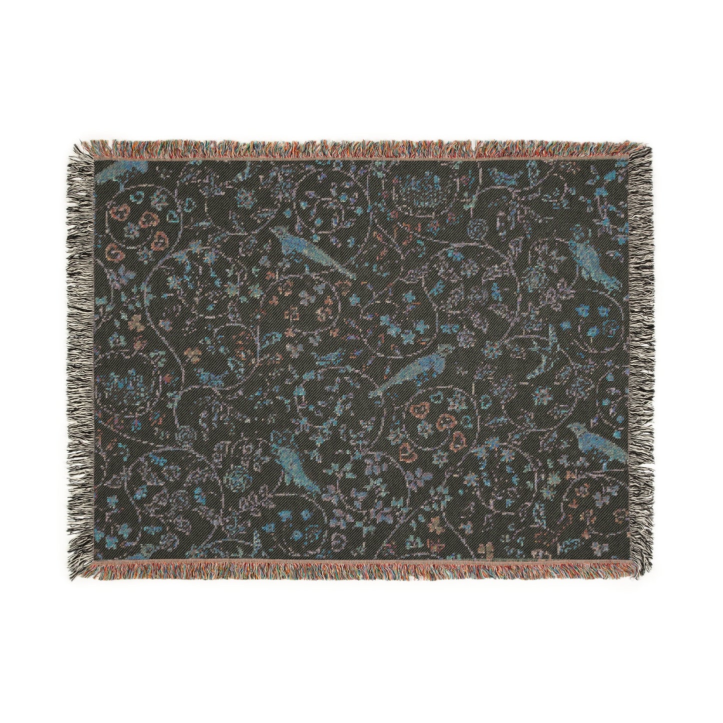 A beige woven cotton blanket with a William Morris & Co floral and bird pattern, featuring a colourful fringed edge.