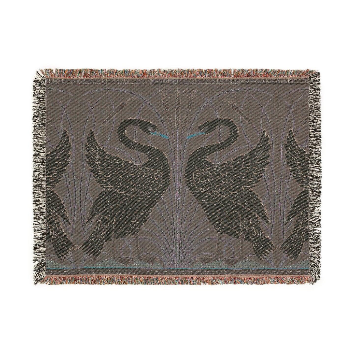A woven cotton blanket with a geometric William Morris & Co pattern featuring swan motifs in a white and green colour scheme with colourful fringed edges.