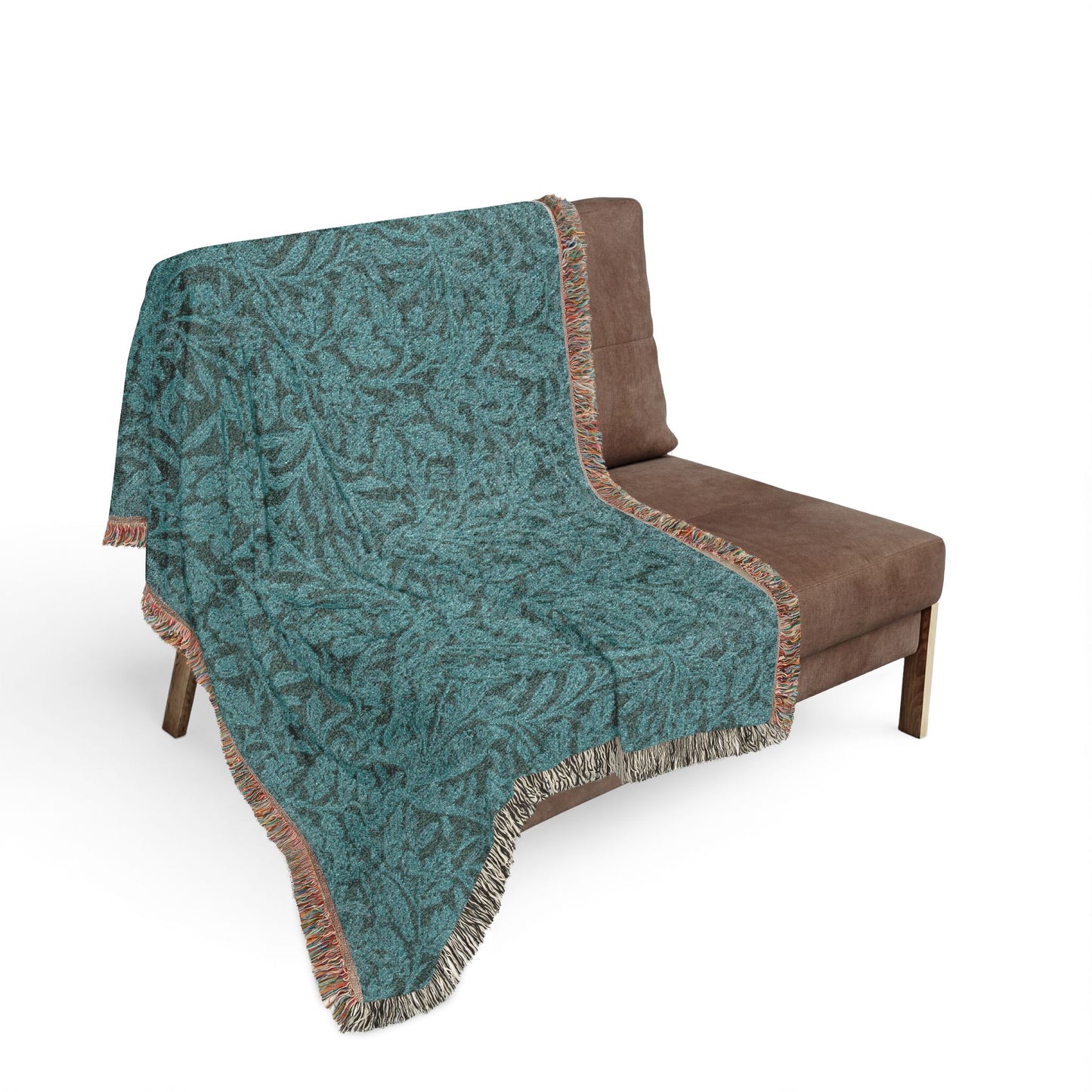 Teal patterned throw blanket draped over a brown chair on a white background