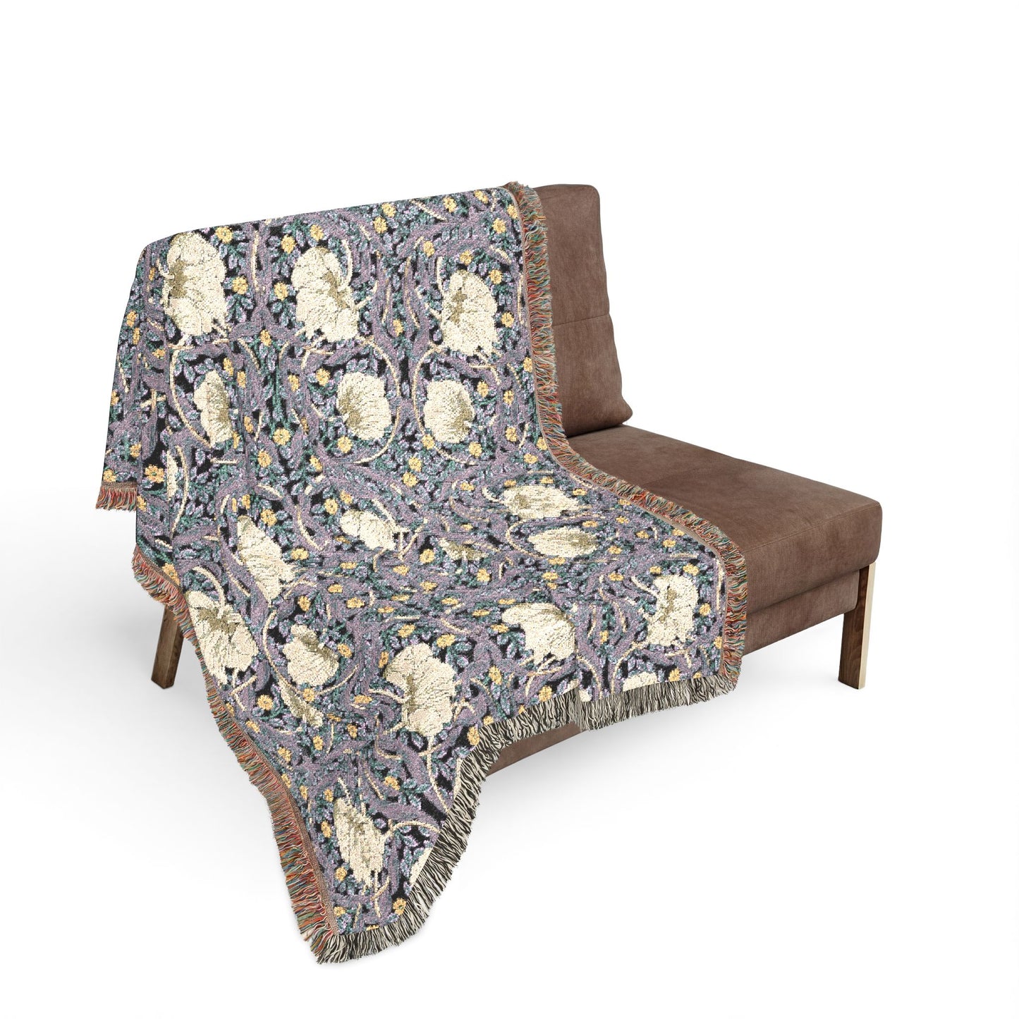 Decorative blanket with floral pattern draped over a brown chair on a white background
