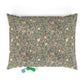 Decorative pillow with floral and bird pattern on a pink background, accompanied by two small toys.