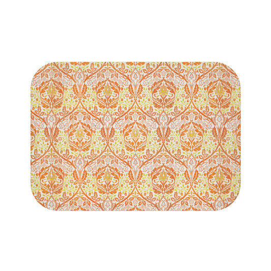 A rectangular microfibre bath mat with a floral pattern inspired by William Morris, in predominantly orange and yellow shades.