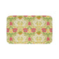 A rectangular microfibre bath mat with a floral pattern inspired by William Morris, in colors green, pink, yellow, and white.