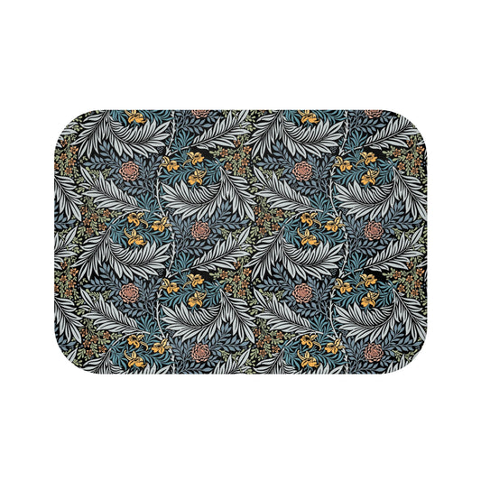 A rectangular microfibre bath mat with a blue background featuring an elegant floral pattern inspired by William Morris' work.
